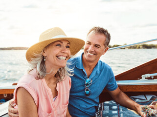 Happy couple, ocean adventure and together in yacht on holiday, relax on cruise date for retirement travel. Mature, woman and man on water boat for vacation with happiness, outdoor summer in Bali