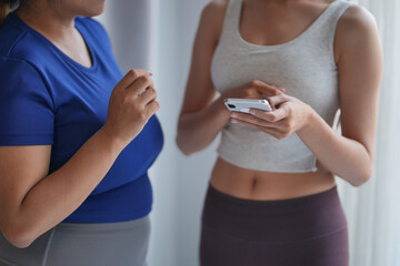 Asian women friends use phone after exercise