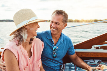 Happy couple, ocean adventure and together in boat on holiday, relax on cruise date for retirement...