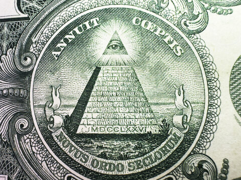 Conspiracy theory concept. All Seeing Eye and Pyramid on USA dollar banknote, macro photo with motion blur effect