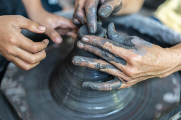 Close-up of hands shaping clay on a spinning pottery wheel.