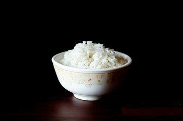 Cooked rice in white bowl on dark background, cooked rice in bowl selective focus, healthy food