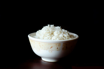 Cooked rice in white bowl on dark background, cooked rice in bowl selective focus, healthy food