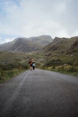 Obraz premium Dad with two kids going to hill and taking picture of nature.