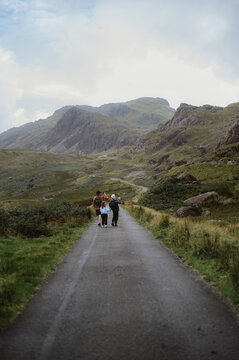 Dad with two kids going to hill and taking picture of nature.