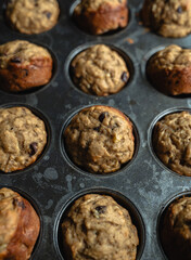 Close up of freshly baked banana chocolate chip muffins in tin.