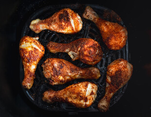 Top view close up of chicken leg drumsticks cooked in air fryer.