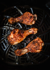Top view close up of chicken leg drumsticks cooked in air fryer.