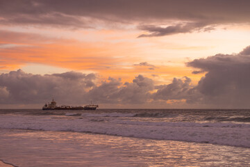 Obraz premium Beautiful Sunrise hues frame dredger in post cyclone recovery
