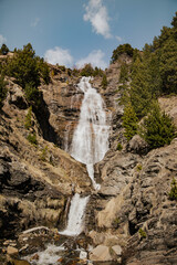 Tall mountain waterfall surrounded by rocky cliffs
