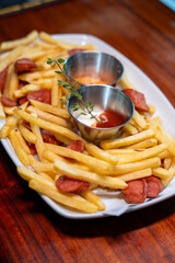 A platter of crispy golden fries, dips, and savory sausage bites that are truly irresistible