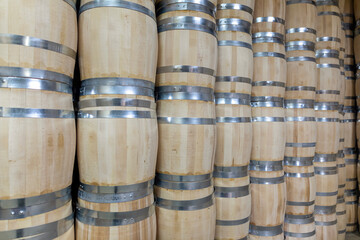 Rows of wooden barrels are neatly stacked in a storage area