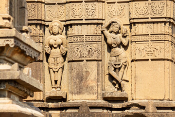 Carved sculptures of Ainak Sundari and other women on Shri Siddheshwara Swamy Temple, Hottal, Nanded, Maharashtra, India.