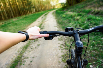 Close-up of woman cyclist hand on handlebars of mountain bike outdoors.