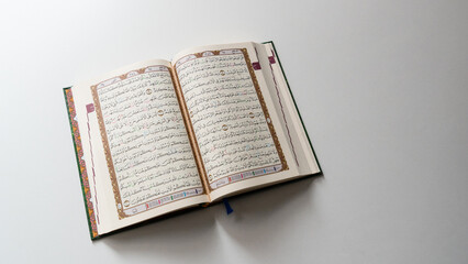 Bandung, Indonesia - 02.11.2025:  Photo of opened Holy Quran with Arabic calligraphy on white...