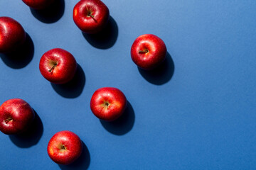 Many red apples on colored background, top view. Autumn pattern with fresh apple above view with copy space for design or text
