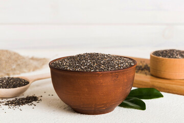 Chia seeds in bowl and spoon on colored background. Healthy Salvia hispanica in small bowl. Healthy superfood
