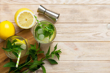 Caipirinha, Mojito cocktail, vodka or soda drink with lime, mint and straw on table background. Refreshing beverage with mint and lime in glass top view flat lay