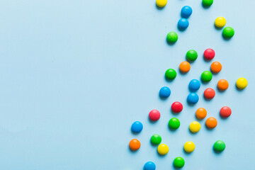 Mixed collection of colorful candy, on colored background. Flat lay, top view. frame of colorful chocolate coated candy