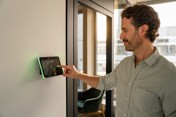 Man using a tablet to book an office in a modern workspace