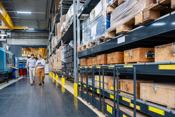 Employees walking and discussing in a production hall warehouse