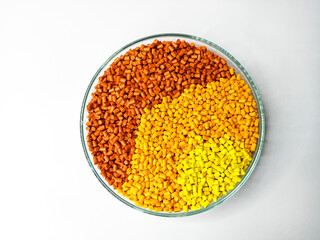 yellow orange color gradation masterbatch granules, in laboratory dish isolated on white background, suitable for product catalog design of plastic manufacturing industry company profile