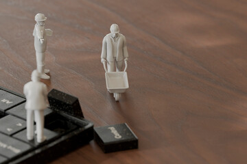 Miniature figurines working on a computer keyboard in a 3D conceptual art setting