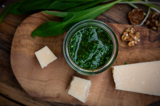 Wild garlic pesto with walnuts and parmesan on dark wood