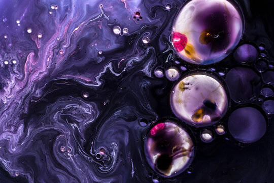 Swirling patterns of ink and oil create beautiful bubbles in an abstract design