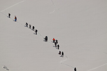 チームで雪山を登る登山ツアー 協力と冒険の冬景色