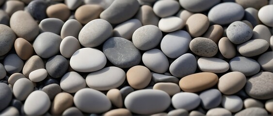 Close-Up of Smooth, Round Beach Pebbles in Various Shades of Gray, White, and Tan - Textured Background                                               