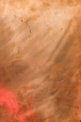 Soft glow copper backdrop. Red glare in the lower left corner. Design surface. Copy space.