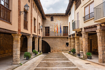 Street with arcades and stone columns in the tourist village of Rafales, Teruel, Spain.
