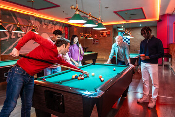 Friends playing billiards in entertainment venue