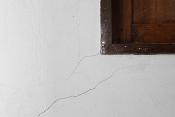 Small hair crack or  damage on concrete wall at corner window. Problem issue from low quality concrete, old, weathered or earthquake. Need repair by epoxy filler for flat smooth.