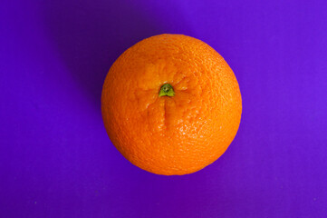 Fresh orange on vibrant purple background. Minimalist pop art style, healthy food concept, bold...