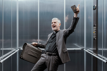 Cheerful priest celebrating alone in an elevator
