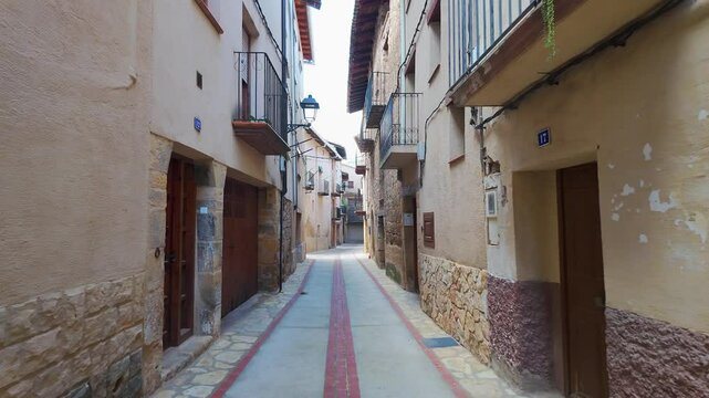 Pigeon flying through the narrow streets of the medieval village of Beceite, Teruel,
