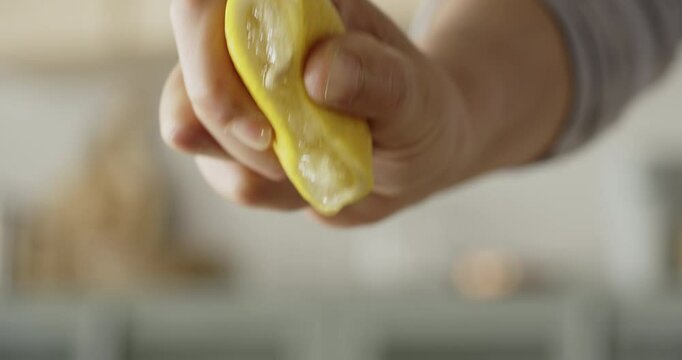 Hand squeezing lemon close up view