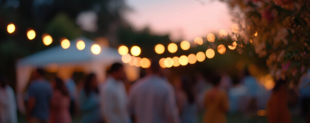 Blurred image of lively backyard party under string lights