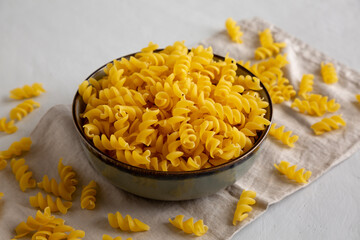 Raw Dry Organic Fusillini Pasta in a Bowl, side view.