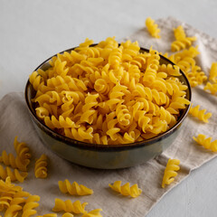 Raw Dry Organic Fusillini Pasta in a Bowl, side view.