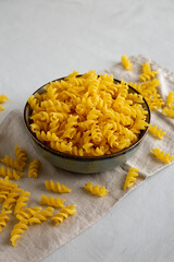 Raw Dry Organic Fusillini Pasta in a Bowl, side view.