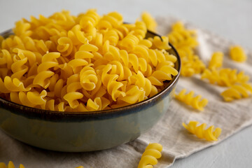 Raw Dry Organic Fusillini Pasta in a Bowl, side view.