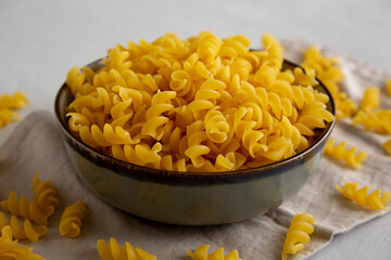 Raw Dry Organic Fusillini Pasta in a Bowl, side view.