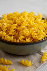 Raw Dry Organic Fusillini Pasta in a Bowl, side view.