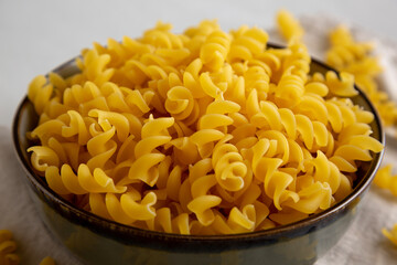 Raw Dry Organic Fusillini Pasta in a Bowl, side view.