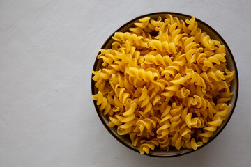 Raw Dry Organic Fusillini Pasta in a Bowl, top view. Copy space.