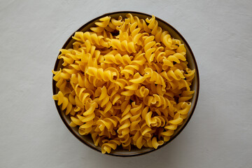 Raw Dry Organic Fusillini Pasta in a Bowl, top view.