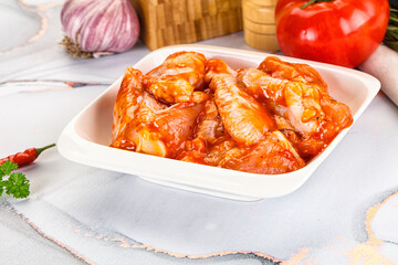 Raw marinated uncooked chicken wings